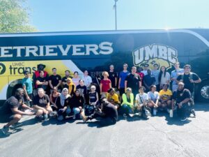 people smiling in front of umbc bus